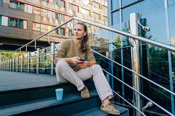 Atrakcyjne stylowy hipster facet siedzi na schodach autobusów — Zdjęcie stockowe