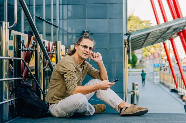 Atrakcyjne stylowy hipster facet siedzi na schodach autobusów — Zdjęcie stockowe