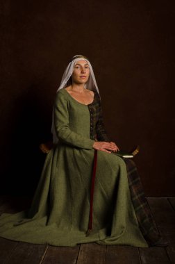 Ortaçağ kostümü giymiş güzel, sofistike bir aktris.