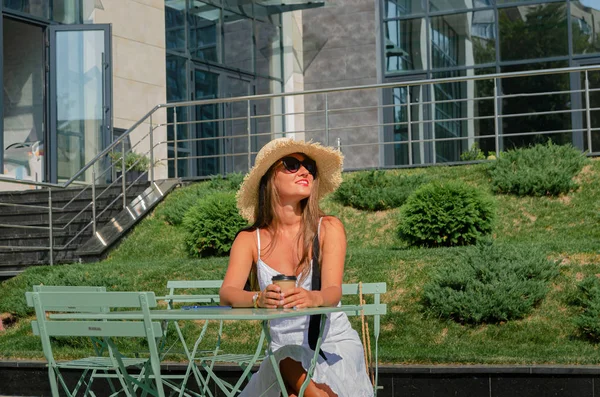 Hermosa mujer bronceada delgada en un sombrero de paja y un sundre blanco — Foto de Stock