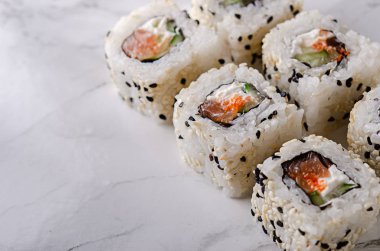 Somon, salatalık, krem peynir ve susamlı suşi.