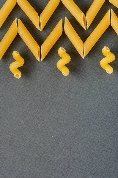Briefkaart, achtergrond - Italiaanse traditionele pasta penne (veren) — Stockfoto