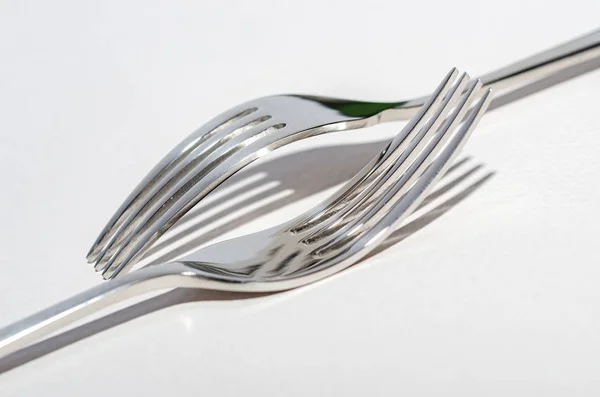 Two metal shiny forks on a light background. — Stock Photo, Image