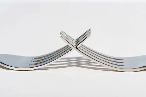 Dos tenedores metálicos brillantes sobre un fondo claro . — Foto de Stock