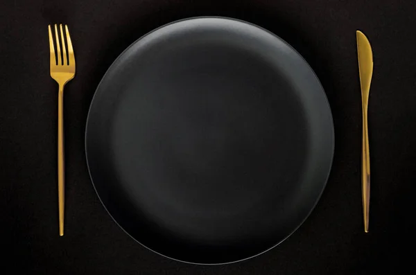 Черная Пустая Керамическая Плита Золотыми Столовыми Приборами Вилка Нож Черном — стоковое фото