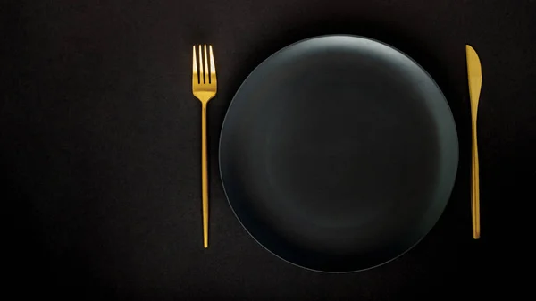 Black Empty Ceramic Plate Golden Cutlery Fork Knife Black Background — Stock Photo, Image