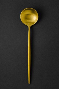 Modern çatal bıçak takımı altın kaşıktır. Siyah arkaplanda çatal bıçak takımı