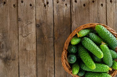 Eski ahşap bir masanın üzerinde salatalık sepeti. Kırsal yaşam