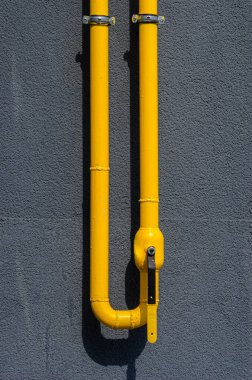 Çok katlı bir binanın ön cephesinde havalandırması olan sarı gaz borusu. Ev içi kullanım için doğal gaz, gaz boru hattı. Konut binalarının gazlaştırılması