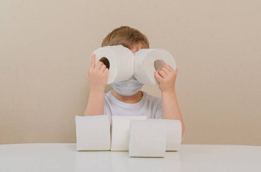 Koruyucu maske takmış, tuvalet kağıdıyla oynayan dört yaşında tatlı bir çocuk. Teleskopla bakıyor. Çocuklarla ev karantinası, aile eğlencesi. Panovirüs (salgın) panovirüs paniği