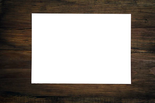 Foglio di carta bianco su scrivania di legno scuro . — Foto Stock