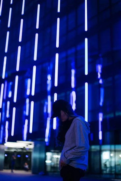 美丽的年轻女子穿着时髦的衣服摆在夜间城市街道上. — 图库照片