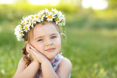 Çiçek çelengi olan bir çocuk..