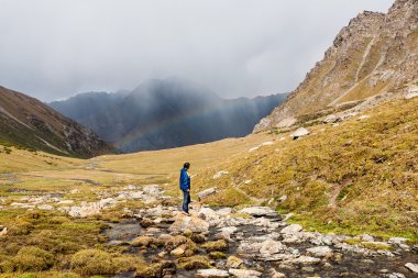 Uzun yürüyüşe çıkan kimse bir dağın tepesinde rahatlatıcı