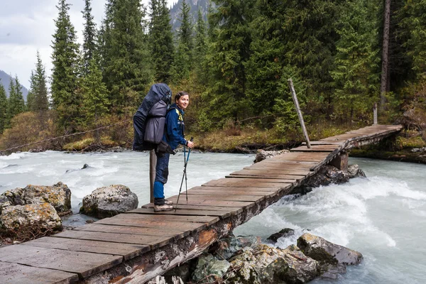 Escursionista attraversando il fiume a Tien Shan montagne — Foto Stock