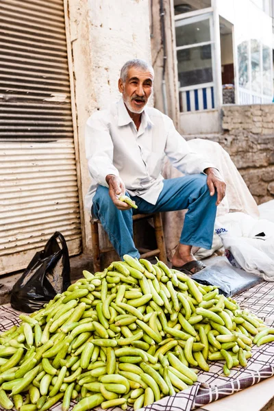 El hombre vende pepinos en el mercado . — Foto de Stock