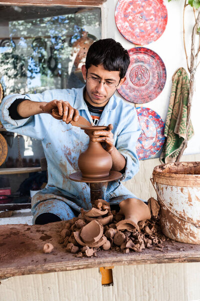 An unknown artist works on a traditional ceramic vase in Cappado