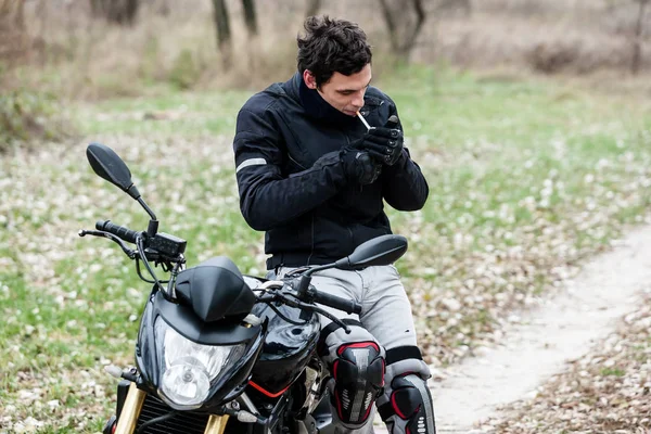 Motosiklet üzerinde oturan ve onun sigara motorcu — Stok fotoğraf