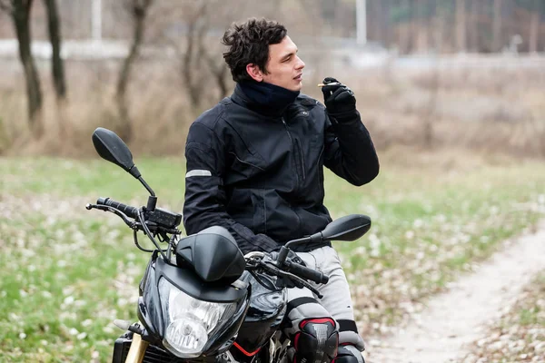 Biker sedí na motorce a kouří cigaretu — Stock fotografie