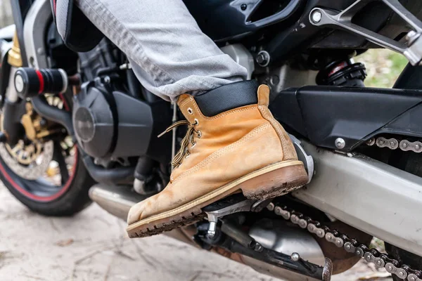 Biker sentado na motocicleta, close-up vista sobre as pernas . — Fotografia de Stock