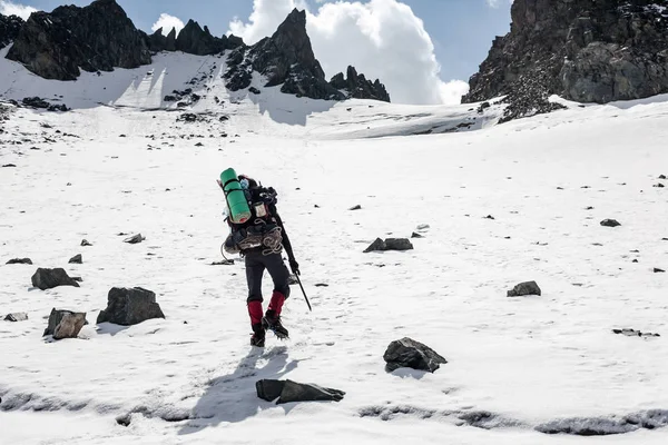Wanderer bewegt sich auf eis- und schneebedecktem Land im Tianshan-Gebirge — Stockfoto