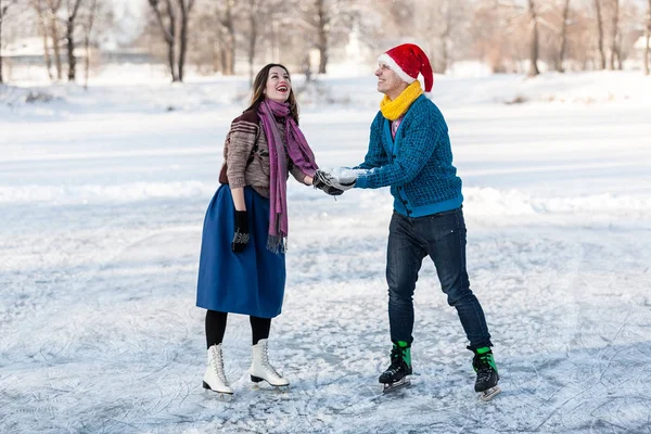 Lyckliga paret ha kul skridskoåkning på isbanan utomhus. — Stockfoto