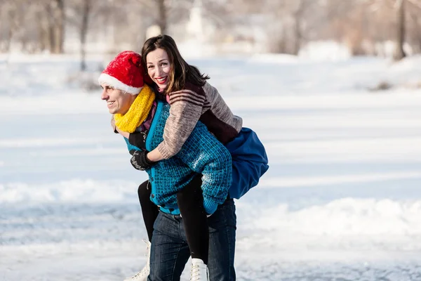 Lyckliga paret ha kul skridskoåkning på isbanan utomhus. — Stockfoto