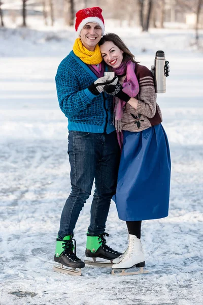 Lyckligt par ha kul is åka skridskor och dricka varmt te från th — Stockfoto