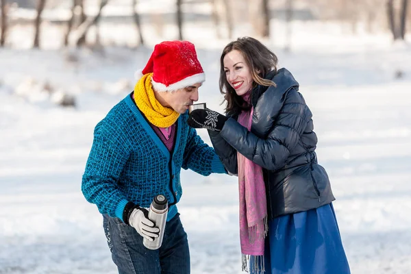 Gelukkige paar plezier ijs schaatsen en drinken van hete thee van th — Stockfoto