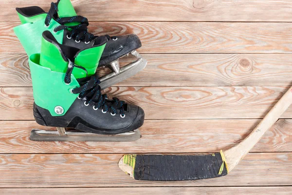Blick auf Hockeyschläger und Schlittschuhe auf altem rustikalem Holz — Stockfoto