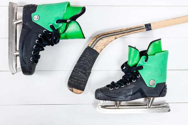 Bovenaanzicht van hockeystick en ijs-of rolschaatsen op oude rustieke woode — Stockfoto