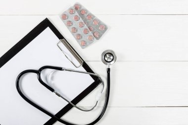 Tıbbi Pano ve stetoskop Beyaz ahşap masa backgrou üzerinde