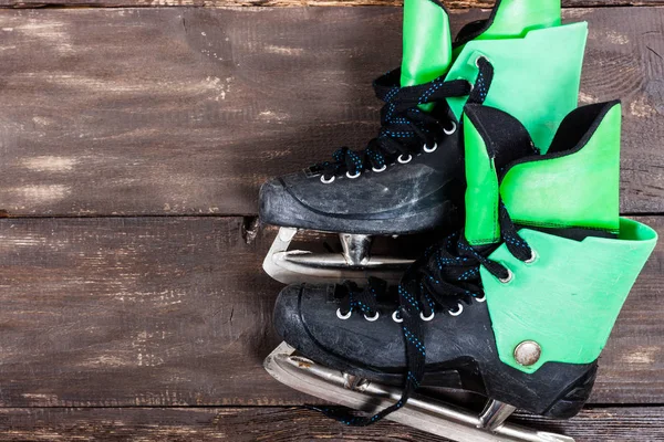 Vista aérea de patines de hockey sobre hielo sobre una vieja mesa rústica de madera . — Foto de Stock