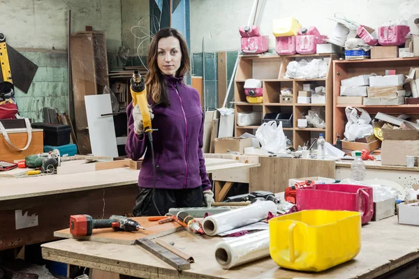 Women worker using instruments to make furniture