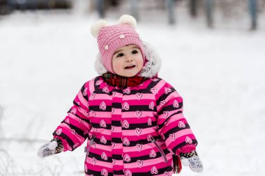 Sevimli küçük kız açık doğa üzerinde kış eğleniyor.