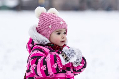 Sevimli küçük kız açık doğa üzerinde kış eğleniyor.