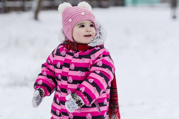 Söt liten flicka ha kul utomhus på naturen på vintern. — Stockfoto