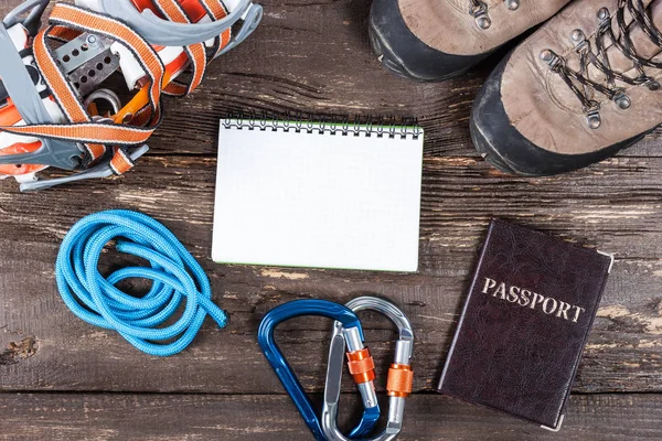 Equipment for mountaineering and hiking on wooden background.