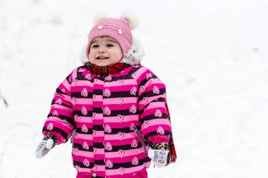 Sevimli küçük kız açık doğa üzerinde kış eğleniyor.