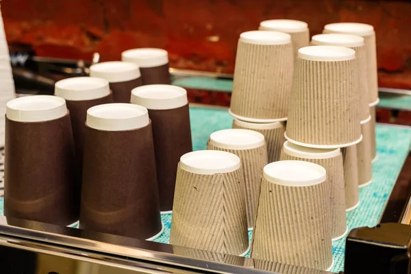 A coffee machine with a large stack of paper cups next to it. — Stock Photo, Image