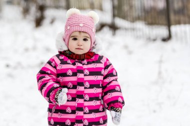 Sevimli küçük kız açık doğa üzerinde kış eğleniyor.