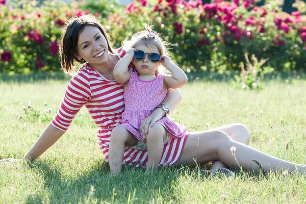 Moeder en dochter in een park. — Stockfoto