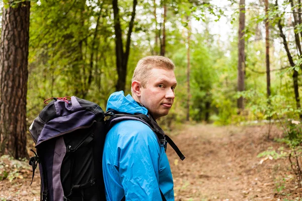 Wanderer mit Rucksack ist im Herbstwald unterwegs. — Stockfoto