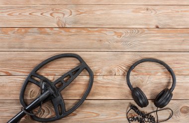 Eski rustik ahşap masanın üzerine yerleştirilen metal detektörü aksesuarları.