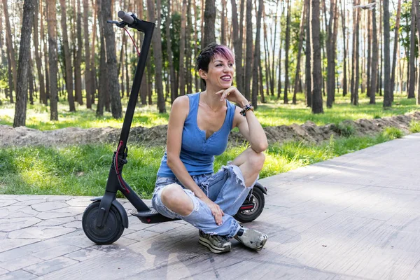 Cool attraktiv kvinna njuter av att rida en elektrisk skoter — Stockfoto