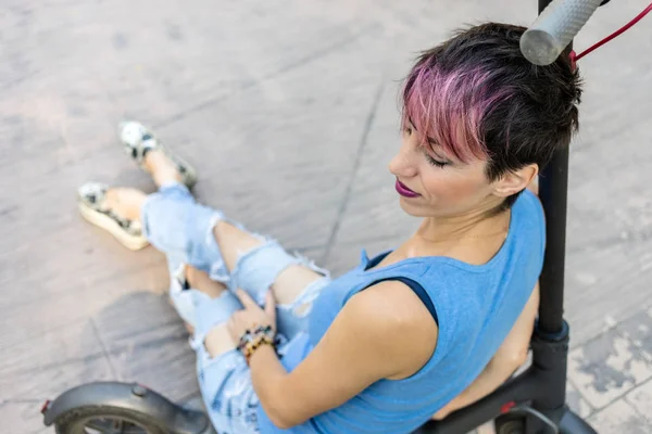 Havalı çekici kadın elektrikli scooter sürmekten hoşlanıyor. — Stok fotoğraf