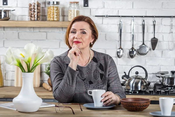 Senior zakenvrouw ontspannen bij balie Kitchen — Stockfoto