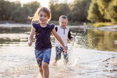 Yazın suda koşan iki mutlu çocuk