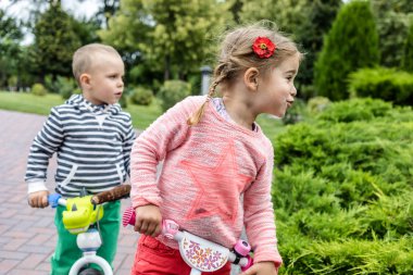 Gündüz yolda eğlenen bisikletli mutlu çocuklar.