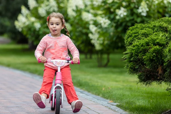 Gelukkig meisje op een kleine fiets. — Stockfoto